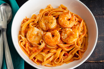 Bowls of Shrimp and Pasta in Tomato Cream Sauce: Bowls of shrimp and fettuccine pasta noodles in a creamy tomato sauce
