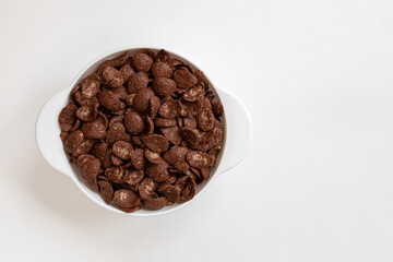 chocolate flakes in bowl on white background, healthy breakfast concept
