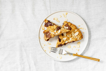 Two pieces of homemade shortbread pie with milk and bitter chocolate in a plate on a white culinary background top view from a copyspace. Delicious sweet pastries