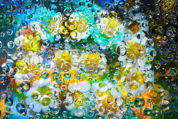 Transparent raindrops falling down against the black-blue background with silhouettes of...