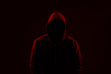 Silhouette of anonymous man on dark background, toned in red