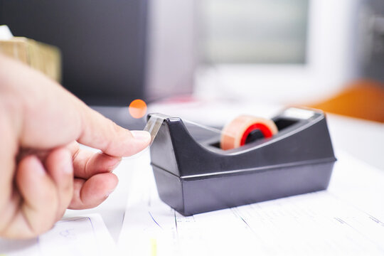 A Hand Of Unrecognizable Person Taking A Piece Of Packing Tape