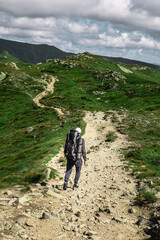 Fototapeta premium young hiker man in mountains. summer trekking path