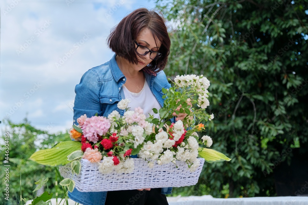 Wall mural Female florist working with flowers outdoors, decorating events with flowers