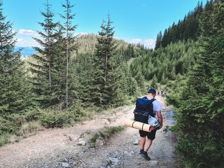 Fototapeta premium young hiker man in mountains. summer trekking path