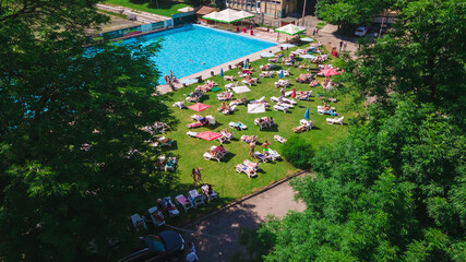 aerial view of people resting sunbathing near city pool