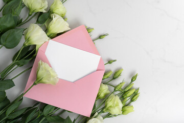 Real photo. Pink envelope square invitation card mockup with a eustoma flowers. Top view with copy space, light gray marble background. Template for branding and advertising