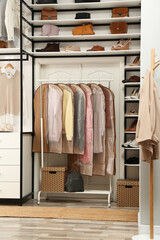 Garment bags with clothes on rack in dressing room