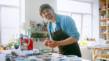 A young master in an apron at work in his workshop