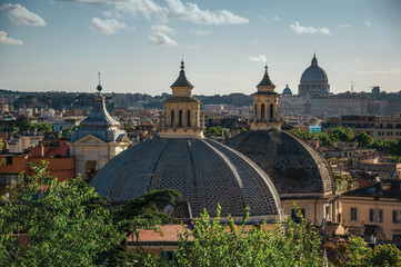 Overview of trees, cathedrals domes and roofs of buildings in Rome. The incredible city of the Ancient Era, known as The Eternal City. Central Italy.