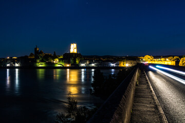 Fototapeta premium Vue nocturne en longue exposition de Pont-Saint-Esprit, au bord du Rhône (Occitanie, France)