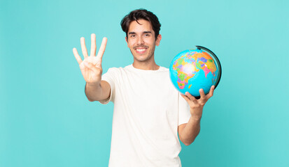 young hispanic man smiling and looking friendly, showing number four and holding a world globe map