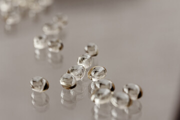 Transparent yellow capsules Vitamin D3, Omega, on glass background, table