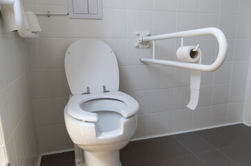 Bathroom equipped with toilet for the elderly and disabled people with fall prevention handle.