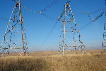 High voltage tower. Electrical lines in the field on clear sky Electricity supply transmission