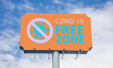 Covid free zone sign. COVID-19 free zone text on a billboard, blue sky background.