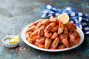 Cooked shrimp with lemon and herbs butter sauce. Spiked shrimp-bear on a white plate, selective focus