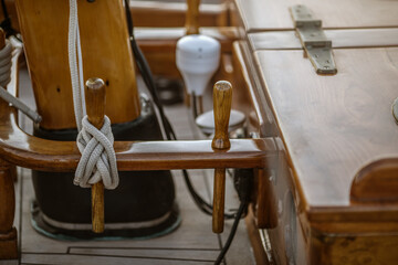 Detail closeup of wooden cleats with nautical moored ropes of sailboat.