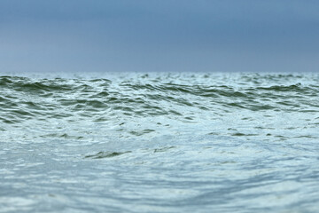 Close up of sea wave in pleasant blue and green tones low angle view water background. Summer holiday concept.