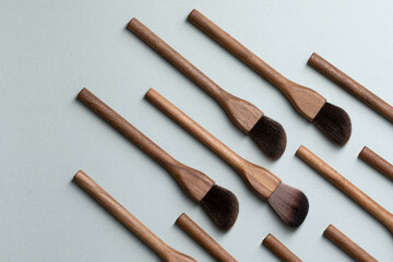 Set of natural wood vegan make up brushes on bluebackground. Top view, copy space. Eco-friendly, no plastic zero waste concept