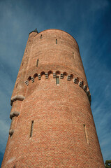 Close-up of brick tower and blue sky, early in the morning at Bruges. A graceful town that is a World Heritage Site of Unesco. Northwestern Belgium.