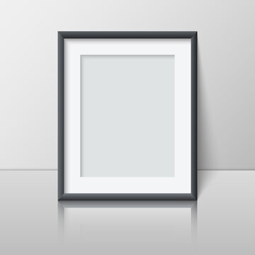 Realistic vertical blank picture frame stands near the wall on the shelf. Empty photo frame mockup with reflection for pictures, photograph, poster. Decorative design element interior. Vector