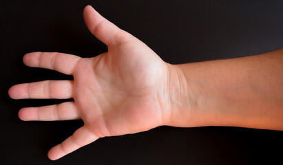 Fototapeta na wymiar Palma da mão de mulher madura sobre fundo preto.