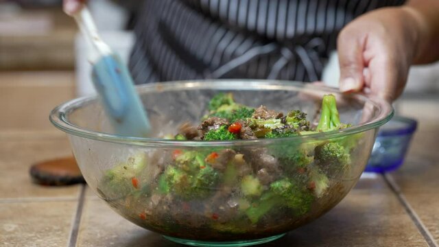 Stirring broccoli into a freshly fried and steaming broccoli dish with other ingredients