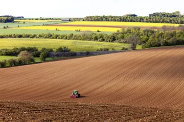 Poster A tractor and seed drill sowing on Cotswold brash soil near the Cotswold village of Hampen, Gloucestershire UK © Stephen