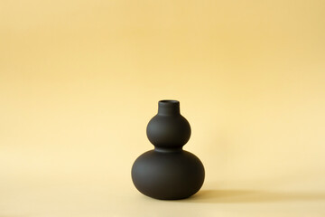 Black matte vase on a delicate background