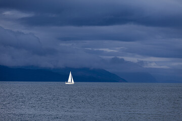 A yacht sailing off the coast of the Isle of Mull, Argyll and Bute, Inner Hebrides, Scotland, UK