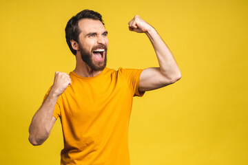 Fototapeta premium Happy winner! Portrait of shocked amazed young male man keeps mouth widely opened, being surprised, expresses great surprisment. Isolated over yellow background.