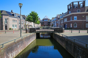 Fototapeta premium Helmond, Netherlands - July 10. 2021: View over water canal on traditional old dutch houses in summer with blue sky