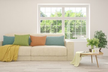 White living room with sofa and summer landscape in window. Scandinavian interior design. 3D illustration