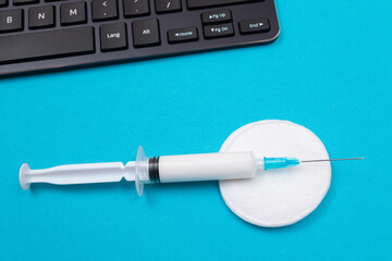 Vaccination, Immunology or Revaccination Concept - A Medical Syringe Lying on Blue Table in...
