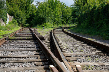 Bifurcation in the railway tracks. Rusty railway rails and rotten wooden sleepers are overgrown...