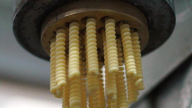 The making of fusilli pasta dough with special equipment in slow-motion, HD