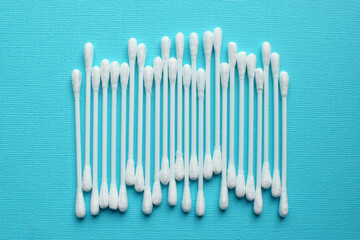 Lots of plastic cotton swabs on a blue background.