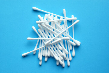 Lots of plastic cotton swabs on a blue background.