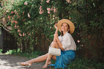 Summer street fashion conception: elegant happy woman wearing straw hat, vintage style blouse,...