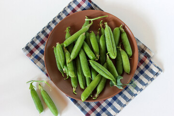 green pea pods on a brown plate.
