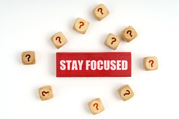 On the table are cubes with questions and a red plaque with the inscription - Stay Focused