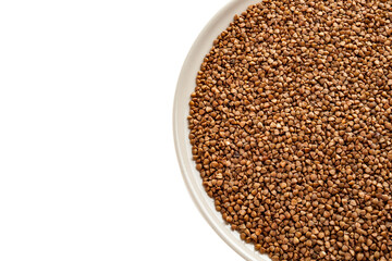 Buckwheat, raw, not boiled in a plate, close-up, isolated on a white background, buckwheat porridge