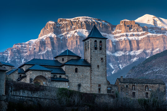 View of the church of San Salvador in Torla-Ordesa with the snow-capped mountains in the background