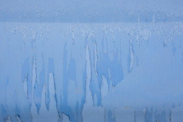 peeling off old blue paint on vehicle - close-up with selective focus