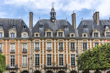 Fototapeta na wymiar Typical building at Place des Vosges (known as Place Royale) - oldest planned square in Paris, in Marais district. Place des Vosges built from 1605 to 1612. Paris, France.