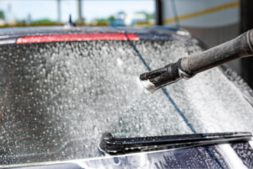 Car wash. The process of washing a car with active foam under pressure. Self-service manual car wash. Car care concept