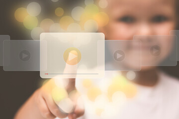 A little girl chooses a video to watch. The child's finger presses the video play button. A...