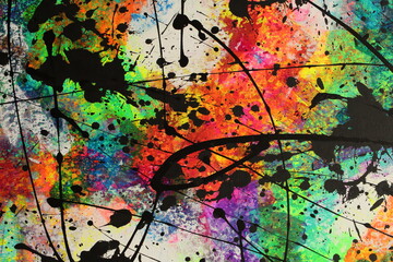 Obraz na płótnie Canvas Bright neon colors explode across the canvas and are covered by messy black splatters of acrylic paint.