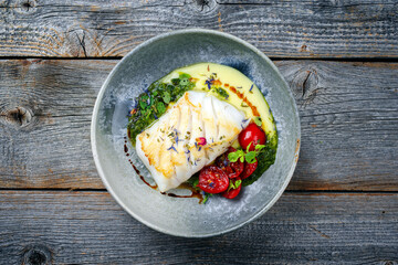 Modern style traditional fried skrei cod fish filet with mashed potato cream and coriander lime relish served as top view on Nordic design plate with copy space - obrazy, fototapety, plakaty